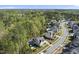 An aerial view of a well-situated home in a lush, wooded neighborhood with a pool and manicured lawns at 3138 Curling Creek Dr, Apex, NC 27502
