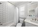 Bright bathroom featuring a shower with a white curtain and hexagon-patterned tile, plus a white vanity with brass fixtures at 3138 Curling Creek Dr, Apex, NC 27502