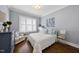 Cozy bedroom with hardwood floors, a white quilted bedspread, and plenty of natural light at 3138 Curling Creek Dr, Apex, NC 27502