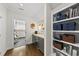 Hallway with hardwood floors, built-in bookshelves and cabinets, and a view into the exercise room at 3138 Curling Creek Dr, Apex, NC 27502