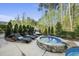 Backyard pool area featuring a hot tub, tanning chairs, and an outdoor cabana at 3138 Curling Creek Dr, Apex, NC 27502
