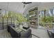 Covered porch with fireplace, ceiling fan, and comfortable seating overlooking the wooded backyard at 3138 Curling Creek Dr, Apex, NC 27502