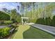 Backyard putting green and bocce court with landscaped yard and a pergola at 3138 Curling Creek Dr, Apex, NC 27502