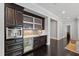 Stylish bar area featuring dark cabinetry, wine fridge, mosaic tile backsplash, and marble countertops at 3312 Rock Creek Dr, Raleigh, NC 27609