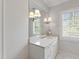 Well-lit bathroom with a marble countertop, white cabinets, and a window with shutters at 3312 Rock Creek Dr, Raleigh, NC 27609