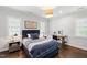Stylish bedroom featuring a dark blue headboard, wooden floors, and bright natural light at 3312 Rock Creek Dr, Raleigh, NC 27609