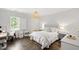 Cozy bedroom with wood floors, a window with shutters, and a bed with a cushioned headboard at 3312 Rock Creek Dr, Raleigh, NC 27609