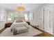Bright primary bedroom with a tufted headboard, and shuttered windows at 3312 Rock Creek Dr, Raleigh, NC 27609