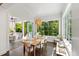 Sunlit dining area with a wooden table, white chairs, and an outside porch view at 3312 Rock Creek Dr, Raleigh, NC 27609