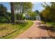 Stunning two-story home featuring a brick driveway and beautiful landscaping with mature trees and vibrant flowers at 3312 Rock Creek Dr, Raleigh, NC 27609
