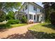 Beautiful white home featuring a brick walkway, manicured lawn, and covered porch with decorative columns at 3312 Rock Creek Dr, Raleigh, NC 27609