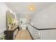 Bright hallway with wood floors, a decorative table with a mirror, and two pendant lights at 3312 Rock Creek Dr, Raleigh, NC 27609