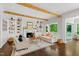 Cozy living room with fireplace, built-in shelving, hardwood floors, and an abundance of natural light at 3312 Rock Creek Dr, Raleigh, NC 27609