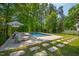 Backyard featuring a rectangular pool surrounded by manicured landscaping and lounge furniture at 3312 Rock Creek Dr, Raleigh, NC 27609