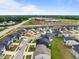 An aerial view shows a community with sidewalks near a school and green fields and lush trees in the background at 3529 Bailey Lake Dr, Fuquay Varina, NC 27526