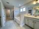 Bright bathroom featuring tile floors, a soaking tub, and a double vanity with gray cabinets at 3529 Bailey Lake Dr, Fuquay Varina, NC 27526