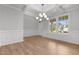 Elegant dining room boasts hardwood floors, wainscoting, coffered ceiling, chandelier, and large windows at 3529 Bailey Lake Dr, Fuquay Varina, NC 27526