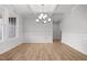 Bright dining area featuring hardwood floors, wainscoting, coffered ceilings, and a modern chandelier at 3529 Bailey Lake Dr, Fuquay Varina, NC 27526