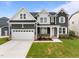 Charming two-story home featuring a two-car garage, manicured lawn, and a mix of gray siding and white trim at 3529 Bailey Lake Dr, Fuquay Varina, NC 27526
