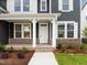 Inviting front porch with brick accents, white pillars, manicured landscaping, and a bright white front door at 3529 Bailey Lake Dr, Fuquay Varina, NC 27526