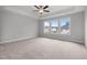 Carpeted main bedroom featuring a trey ceiling, fan, and large windows at 3529 Bailey Lake Dr, Fuquay Varina, NC 27526