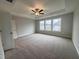 Spacious main bedroom featuring plush carpeting, tray ceilings, and plenty of natural light from large windows at 3529 Bailey Lake Dr, Fuquay Varina, NC 27526
