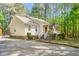 Quaint single-story home featuring a covered porch, tidy landscaping, and a gravel driveway at 3607 Springhollow Ct, Efland, NC 27243