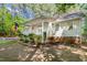 Lovely home with a cozy front porch, surrounded by green bushes and mature trees at 3607 Springhollow Ct, Efland, NC 27243