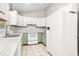 Well-lit kitchen with white cabinets and appliances, complemented by light green lower cabinets at 3607 Springhollow Ct, Efland, NC 27243