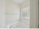 Bright bathroom showcasing a bathtub with jacuzzi jets and a glass block window at 403 Brookgreen Dr, Chapel Hill, NC 27516