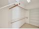 Bright walk-in closet with built-in shelving and wooden hanging rods for ample storage at 403 Brookgreen Dr, Chapel Hill, NC 27516