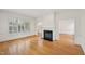 Bright living room features hardwood floors, a fireplace, and large windows with shutters at 403 Brookgreen Dr, Chapel Hill, NC 27516