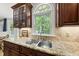 Close up of kitchen with granite counters, stainless steel sink, and dark wood cabinets at 408 Evert Dr, Cary, NC 27511