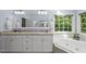 Main bathroom featuring dual sinks, vanity, large mirror and garden tub at 408 Evert Dr, Cary, NC 27511