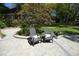 Beautifully landscaped backyard with a stone patio and comfortable Adirondack chairs at 4101 John S Raboteau Wynd, Raleigh, NC 27612