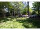 A lush backyard, full of mature trees and flowering bushes, create a beautiful landscape at 4101 John S Raboteau Wynd, Raleigh, NC 27612