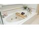 Relaxing bathtub with a caddy for books and accessories, set in a bright and clean bathroom at 4101 John S Raboteau Wynd, Raleigh, NC 27612
