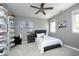 Neutral bedroom featuring a gray accent wall, ceiling fan, and unique sneaker displays at 4101 John S Raboteau Wynd, Raleigh, NC 27612