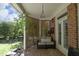 Relax in style on this covered patio with exposed brick, lattice, and a comfortable seating area at 4101 John S Raboteau Wynd, Raleigh, NC 27612