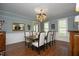 Elegant dining room featuring hardwood floors, wainscoting, chandelier and ample natural light at 4101 John S Raboteau Wynd, Raleigh, NC 27612