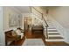Spacious foyer with hardwood floors, a staircase, piano and a decorative bench creating a warm and inviting entrance at 4101 John S Raboteau Wynd, Raleigh, NC 27612