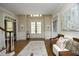 Elegant foyer featuring hardwood floors, a wooden bench, white trim, and large windows at 4101 John S Raboteau Wynd, Raleigh, NC 27612