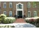 Charming brick home with steps leading to a black front door, complemented by lush landscaping and an arched window at 4101 John S Raboteau Wynd, Raleigh, NC 27612