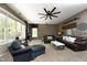 Spacious living room with a ceiling fan, large windows, comfortable seating, and sports decor at 4101 John S Raboteau Wynd, Raleigh, NC 27612