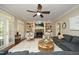 Bright living room with a fireplace, built-in shelves, ceiling fan, and doors to outdoor space at 4101 John S Raboteau Wynd, Raleigh, NC 27612