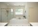 Bathroom showcasing a soaking tub, separate glass shower, and bright natural lighting at 4101 John S Raboteau Wynd, Raleigh, NC 27612