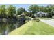 Scenic view of community pond, gazebo, lush greenery, and waterfront homes at 4101 John S Raboteau Wynd, Raleigh, NC 27612