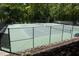 View of community tennis courts surrounded by a black metal fence and lush greenery at 4101 John S Raboteau Wynd, Raleigh, NC 27612