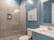 Modern bathroom featuring a glass-enclosed shower with tiled walls and a blue vanity with white countertop at 464 Rosemont Dr, Durham, NC 27713