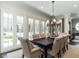 Bright dining room with modern chandelier, hardwood floors, and French doors leading to the outdoor area at 464 Rosemont Dr, Durham, NC 27713